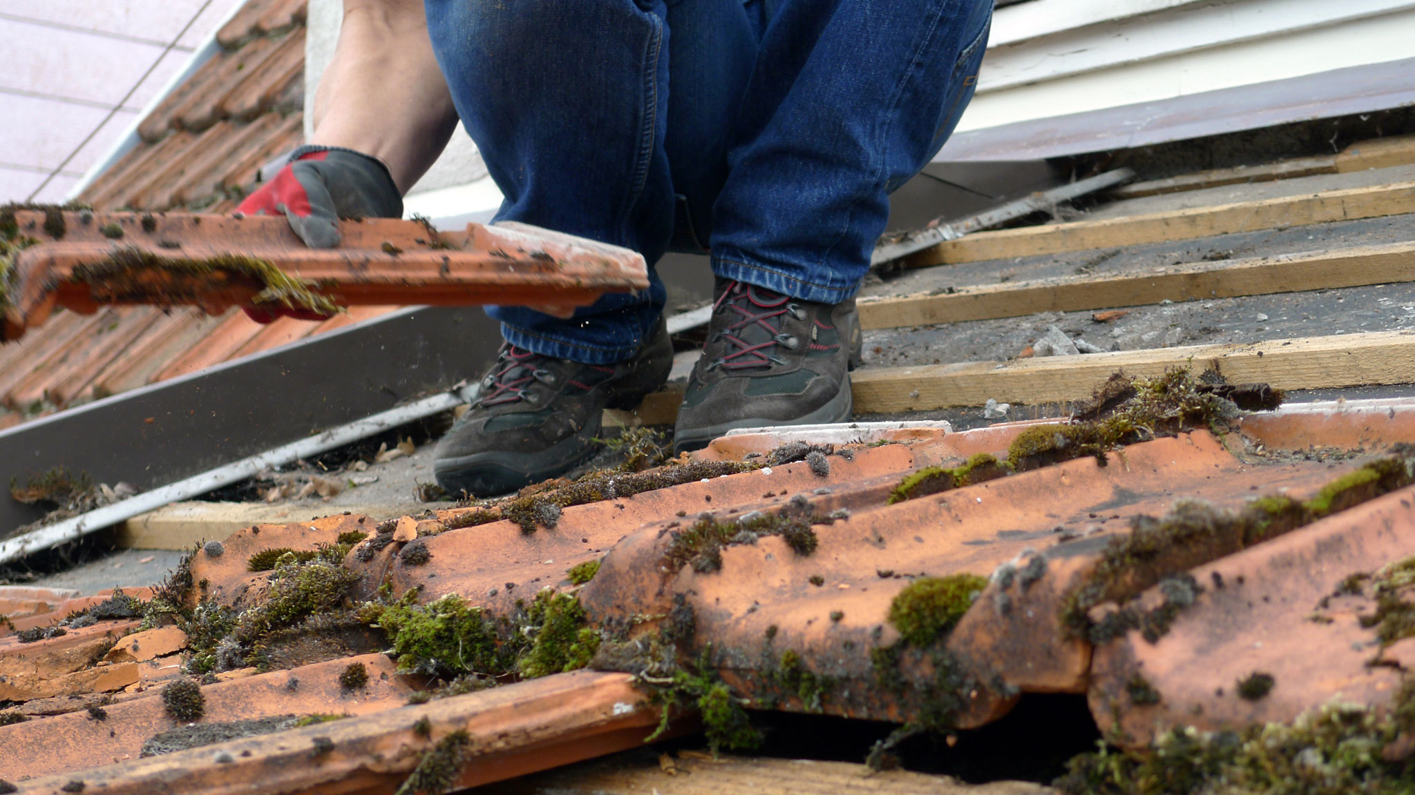 Regelmäßige Wartung und Reparatur spart langfristig Kosten - Dachdecker bei der Dachreinigung und Dachsäuberung