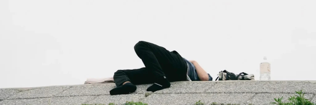Person liegt an einer Kante und ruht sich aus